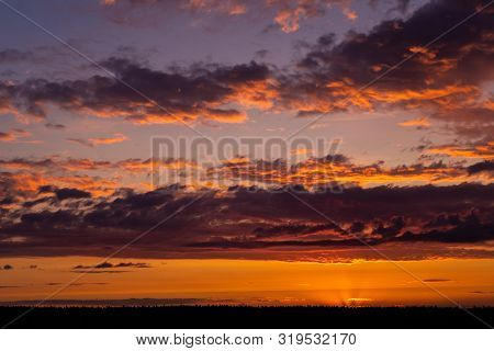 Evening Sky At Sunset Background. Dark Clouds Hanging Above Horizon. Majestic Cloudscape In Blue, Or