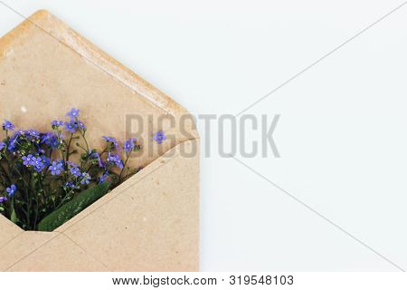 Little Cute Blue Forget-me-nots In A Kraft Paper Envelope, Selective Focus. Beautiful Bouquet Of Blu