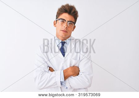 Young handsome sciencist man wearing glasses and coat over isolated white background skeptic and nervous, disapproving expression on face with crossed arms. Negative person.