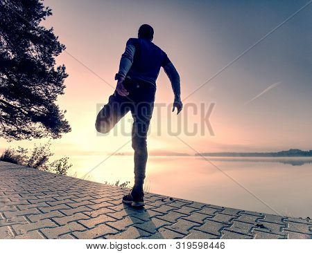 Man Runner Doing Stretching Exercise, Preparing For Morning Workout In The Lake Park. Street Fitness