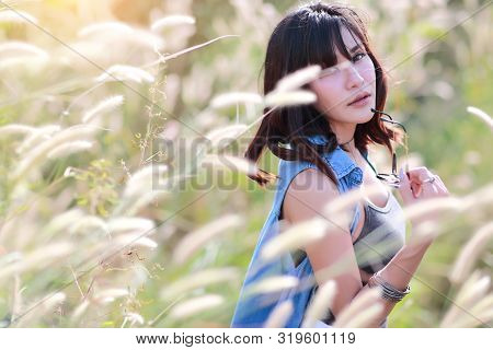 Young And Cute Girl Having A Happy Time And Enoying Amoung Grass Field In Nature