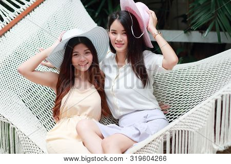 Young And Cute Asian Women With Hat Lying In A Hammock During Holiday