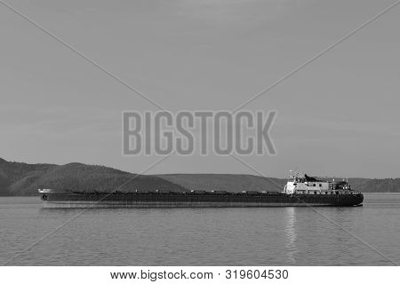 Cargo Ship Located On The Background Of The Mountains. At The Top There Is A Place For Your Text. Bl