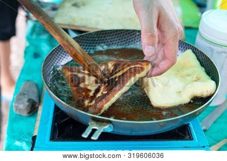 Cooking Pies In The Field On Outdoors. Khachapuri Or Belyash Fried In A Pan