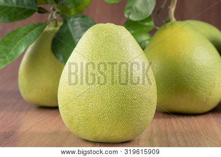 Fresh Peeled Pomelo, Grapefruit, Shaddock With Green Leaves On Dark Wooden Plank Table. Seasonal Fru