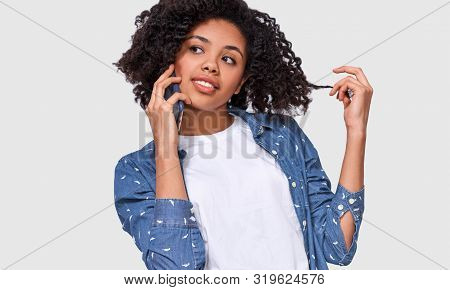 Attractive American African Woman In White T-shirt And Blue Denim Shrit, Talking On Smart Phone To H