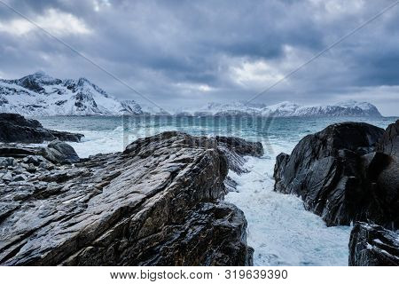 Waves of Norwegian sea crushing at rocky coast in fjord. Vikten, Lofoten islands, Norway