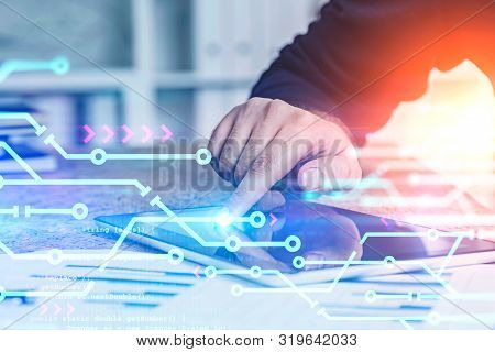 Hand Of Man Using Tablet In Blurred Office With Double Exposure Of Circuits And Lines Of Code. Conce