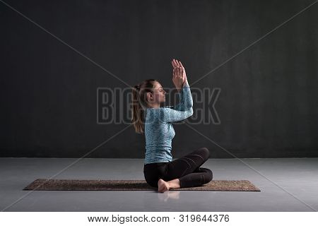 Young Woman Sitting In Gomukhasana, Cowface Pose Variation