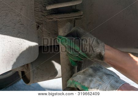 Hands In Defense Gloves Mechanics To Repair The Suspension On The Car. Work With A Wrench. Self-repa