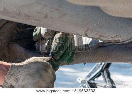 Hands In Defense Gloves Mechanics To Repair The Suspension On The Car. Work With A Wrench. Self-repa