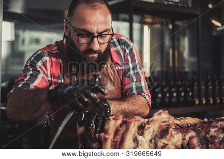 Chef cutting beef carcass in a restaurant