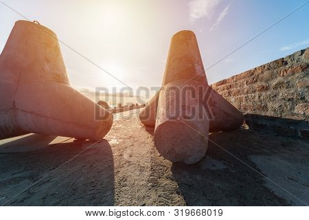 Breakwaters On Pier. Beautiful Sunset Seascape With Concrete Tetrapodes For Protect Coastal Structur