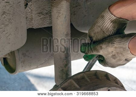 Hands In Defense Gloves Mechanics To Repair The Suspension On The Car. Work With A Wrench. Self-repa