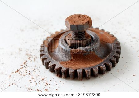 Rusty Bolt, Nut And Gear Wheel Made Of Chocolate Isolated On White Background. Chocolate Chip Scatte