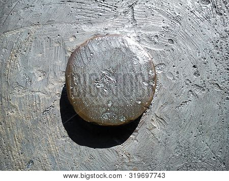 Closeup Of A Sunlit Metal Convex Element With Shadow On A Metal Uneven Background