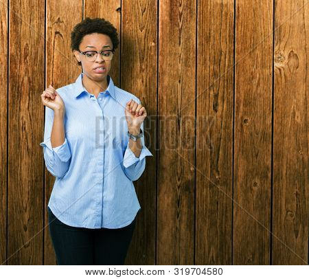 Young beautiful african american business woman over isolated background disgusted expression, displeased and fearful doing disgust face because aversion reaction. With hands raised. Annoying concept.