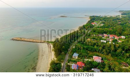 Aerial View Of Coconut Palm Trees Turquoise,houses & Sandy Beach In Pohon Batu Village,labuan Pearl 