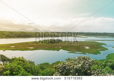A River Of Almost Standing Water Has Vegetation On Both Sides, There Is An Island In The Middle Of T