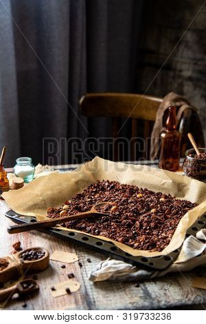 Homemade Baked Chocolate Granola With Nuts, Oat Flakes On Baking Tray With Parchment Stands On Grey 