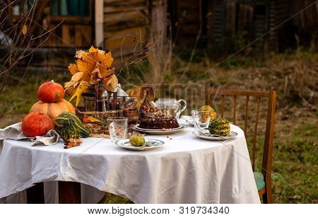 Beautiful Outdoor Still Life In Country Garden With Chocolate Bundt Cake On Plate On Round Table Wit