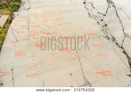 Rock Art In Alta Fjord, Norway. Ancient Symbols, Real Drawing,  Texture In Stone. Red Ocher Paint. H
