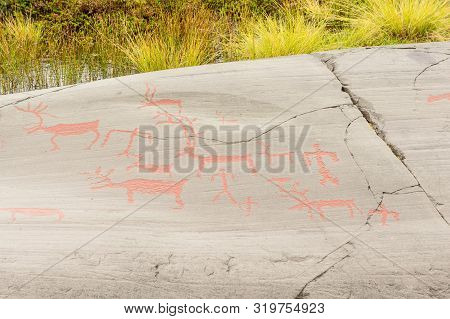 Rock Art In Alta Fjord, Norway. Ancient Symbols, Real Drawing,  Texture In Stone. Red Ocher Paint. H