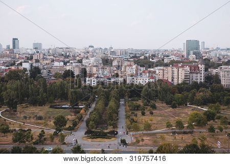 Cityscape Of Old Part Of Bucharest, With Izvor Park In The Foreground, With Many Worn Out Buildings,