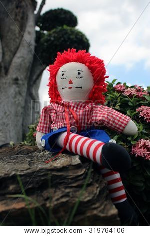 Raggedy Anne Doll Sitting Outside, Old Time Rag Doll, Ghost Mystic Doll. Scary Horror Doll