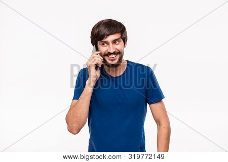 Handsome Brunet Man In A Blue Shirt With Beard And Mostaches Smiling Speaking On The Smartphone Stan