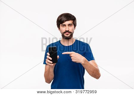 Handsome Brunet Man In A Blue Shirt With Beard And Mostaches Looking At The Camera Pointing At The S