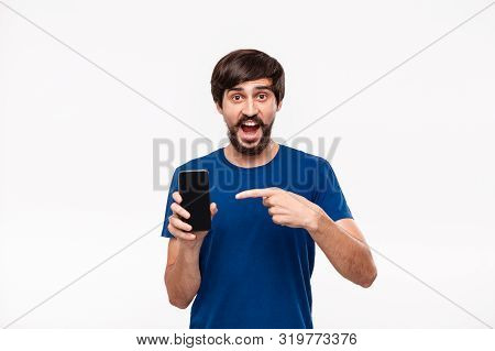 Good Looking Brunet Man In A Blue Shirt With Beard And Mostaches Shocked Looking At The Camera Point