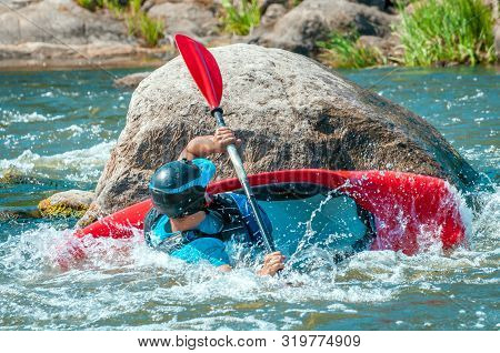 Playboating. A Man Sitting In A Kayak With Oars In His Hands Performs Exercises On The Water. Kayaki