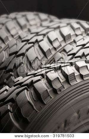Four Off-road Tires On Black Background. Close Up.