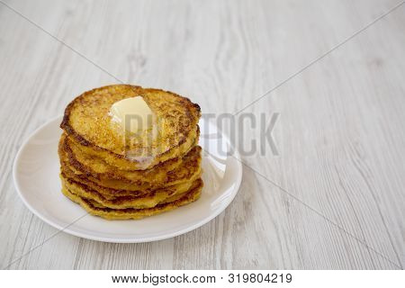 Homemade Corn Meal Johnny Cakes With Butter On A White Plate Over White Wooden Background, Side View