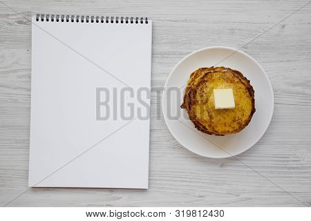 Homemade Corn Meal Johnny Cakes With Butter On A White Plate, Blank Notepad On A White Wooden Backgr