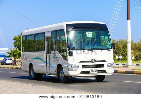 Khor Fakkan, Uae - November 18, 2018: White Passenger Bus Toyota Coaster In The City Street.
