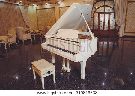 White Piano And Chair . White Piano In The Hall .piano Conner For Relax And Playing Music.