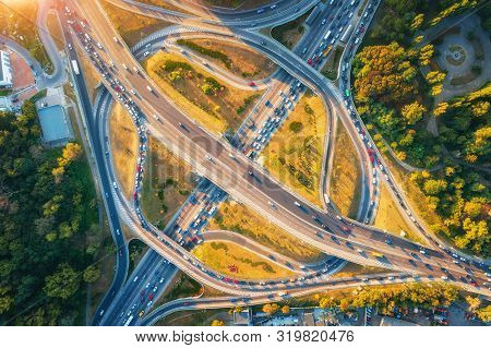 Aerial View Of Road In Modern City At Sunset In Summer. Top View Of Traffic In Highway Junction. Lan