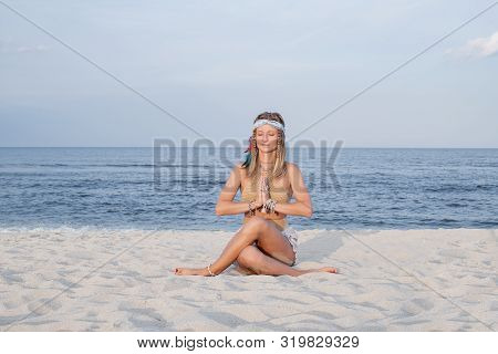 Young Woman Practicing Yoga On The Beach. Gomukasana Pose And Meditation