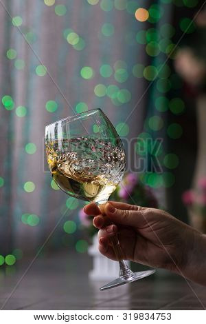Hand Sommelier Holding Glass Of White Wine. Swirling Wine Glass In Wine Tastings  White Wine Concept