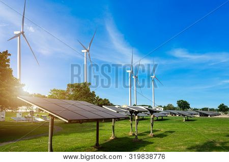 Solar Panels With Wind Turbines Against Mountanis Landscape Against Blue Sky With Clouds,alternative