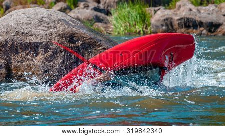 Playboating. A Man Sitting In A Kayak With Oars In His Hands Performs Exercises On The Water. Kayaki