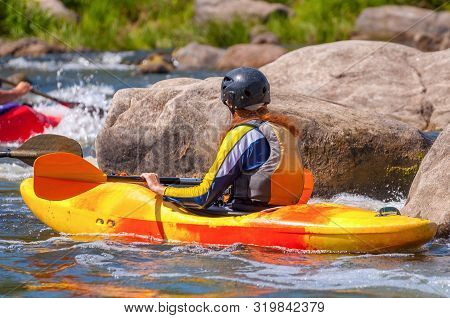 Playboating. A Man Sitting In A Kayak With Oars In His Hands Performs Exercises On The Water. Kayaki