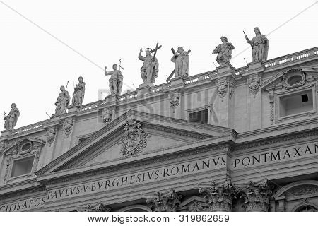 Statues Of Saint And Jesus On Top Of Acade Of Basilica Of Saint Peter In Vatican With Black And Whit