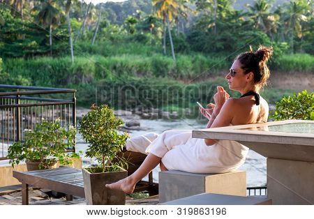 Pinnawala/ Sri Lanka, August 04-2019: Young Woman Relaxing At Swimming Pool Beside A River In Luxury