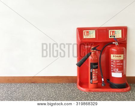 Fire Extinguisher In Workplace Office Against Plain Neutral Background
