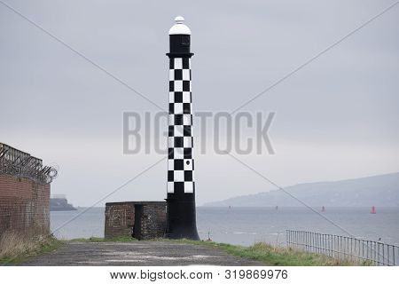 Chequered Black And White Lighthouse At Sea Dock Harbour In Port Glasgow