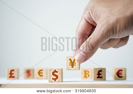 Hand Putting China Yuan Sign To Us Dollar Sign On Wooden Cube.iit Is Symbol Of Economic Tariffs Trad