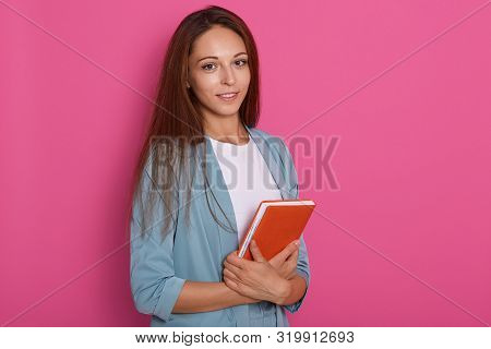 Pretty Young Woman With Dark Straight Hair Standing With Note Book Inhands, Writing, Take Notes, Hol